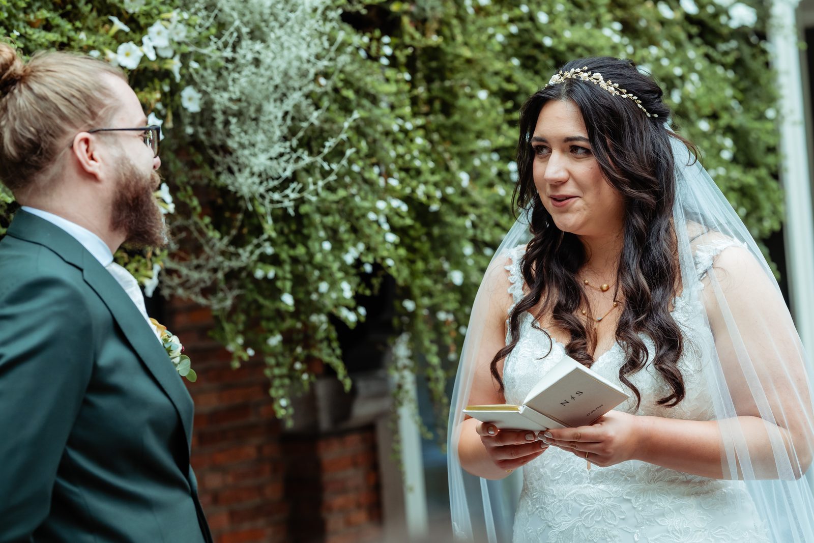 Bruidegom kijkt liefdevol naar de bruid tijdens de ceremonie in Tilburg