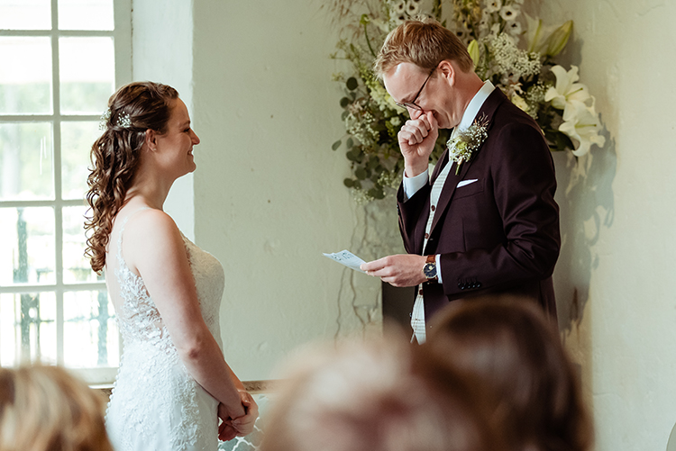 Bruidegom leest ontroerd zijn geloften voor tijdens de ceremonie op Landgoed Klarenbeek