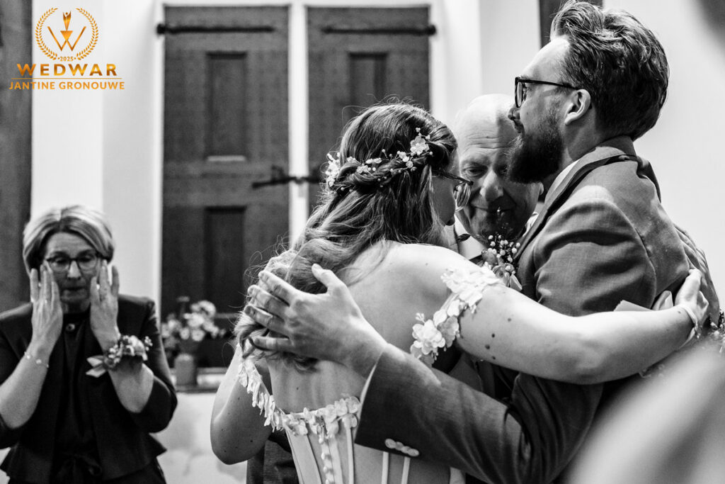 Zwart-witfoto: de vader van de bruid houdt haar handen vast nadat hij haar heeft weggegeven bij de ceremonie. Wedwar Award.